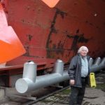Mike Aspray beside part of the iron hull of the SS Great Britain